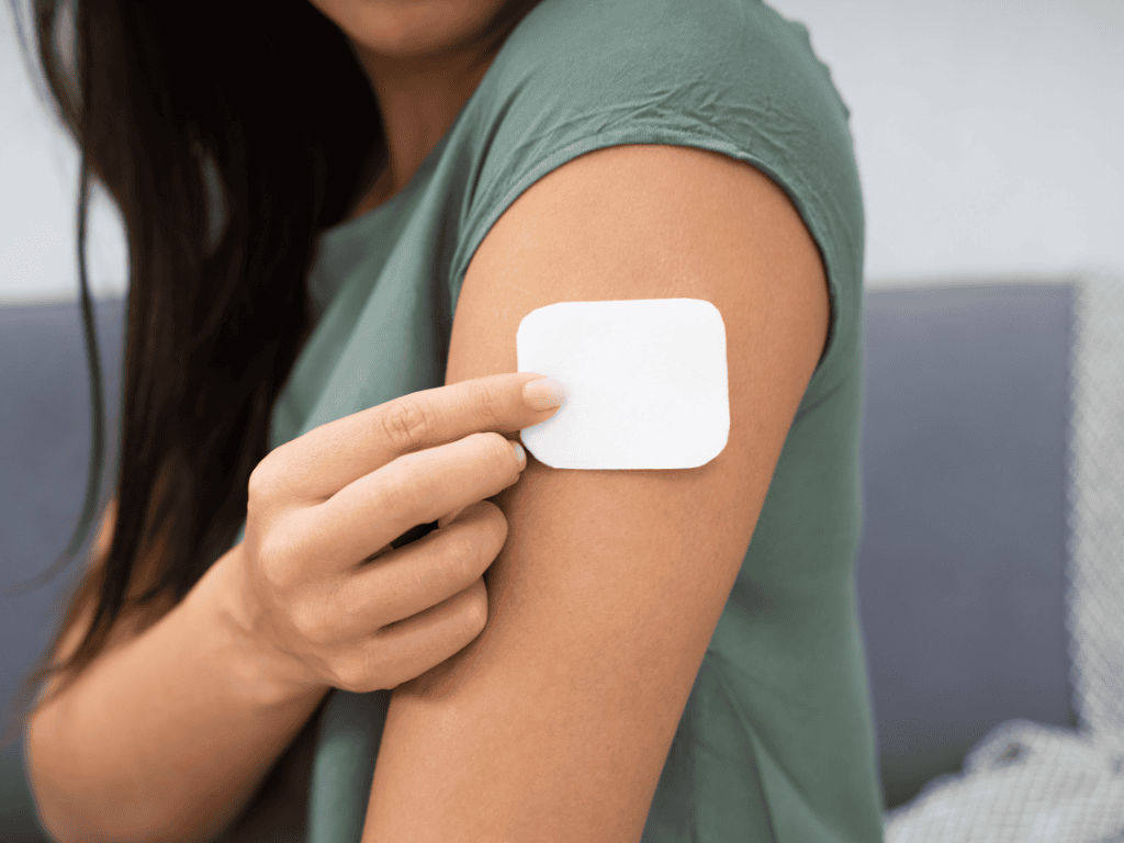 Woman putting a vitamin patch on her arm